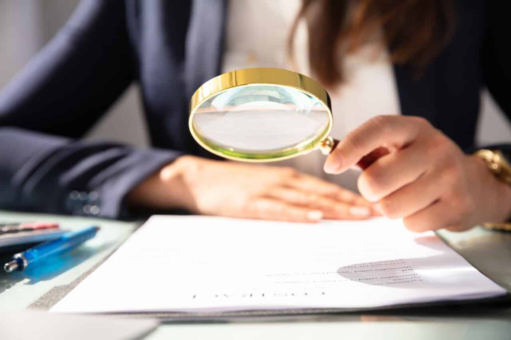lawyer holds a magnifying glass over contract to analyze a force majeure clause