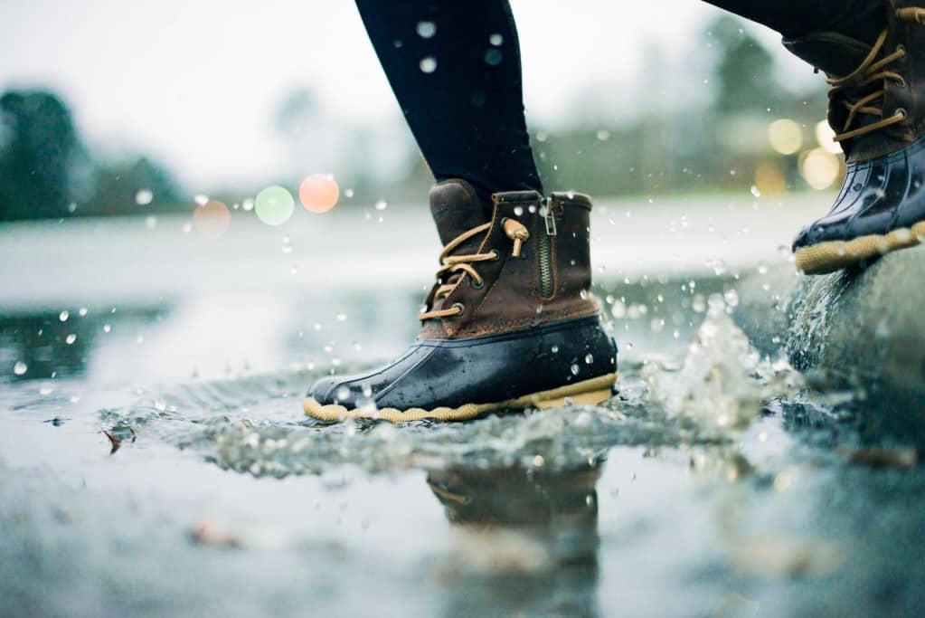 boots splashing in puddle representing the rainy day that led to a personal injury lawsuit