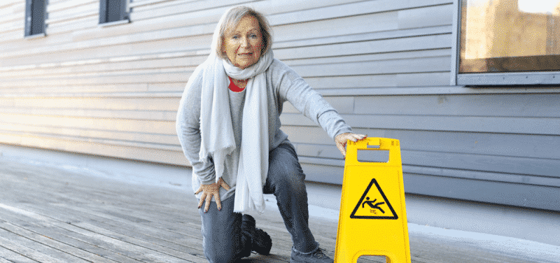 woman on knee with caution sign