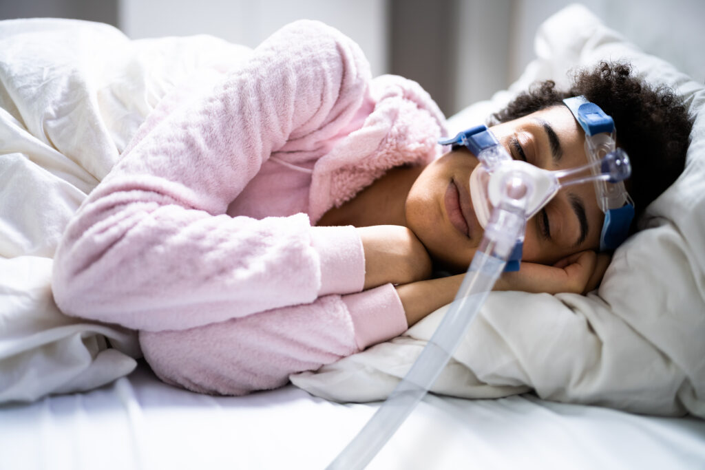 A woman using philips cpap sleep apnea machine